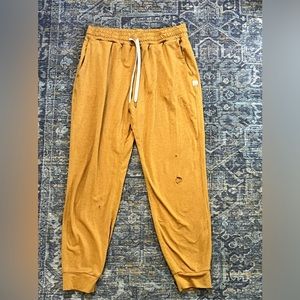 Vuori Joggers in a golden yellow.  3 holes
